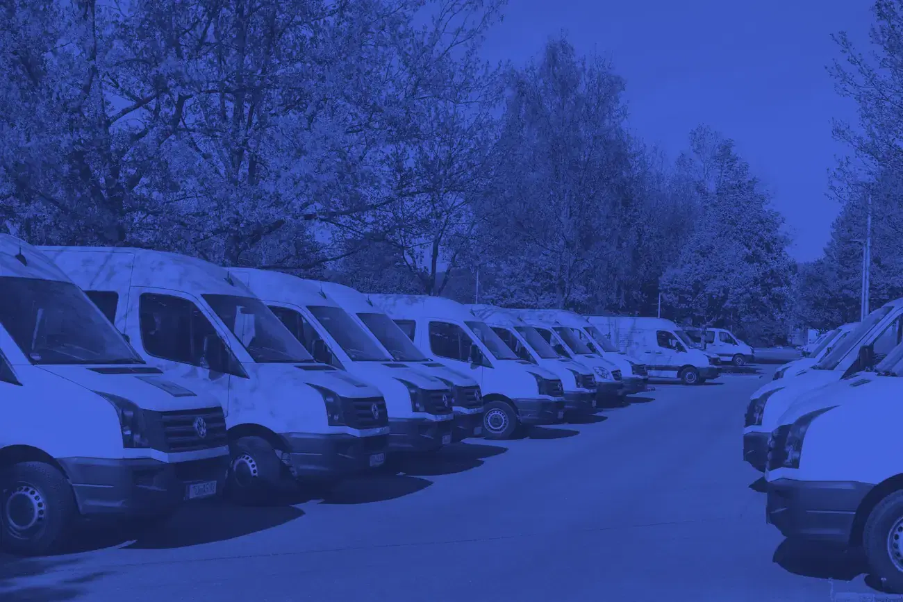 A row of electric delivery vans parked at a fleet depot